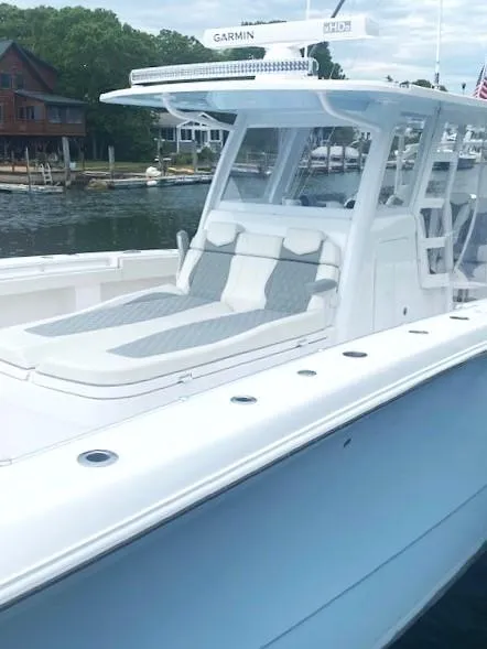 Slide: The Image of 2023 Invincible 46 Catamaran with Quad Axle Trailer, docked near waterfront homes. - 5