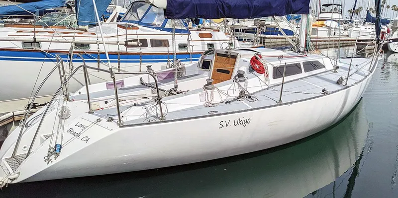 The Image of 1985 Soverel 33 sailboat docked in a marina, featuring sleek white design. - 0