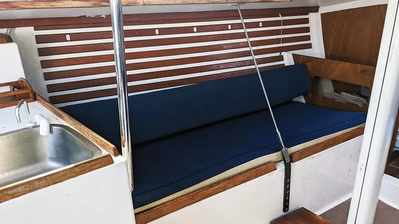 Slide: The Image of Interior of 1985 Soverel 33 sailboat with blue cushioned seating and wooden accents. - 12