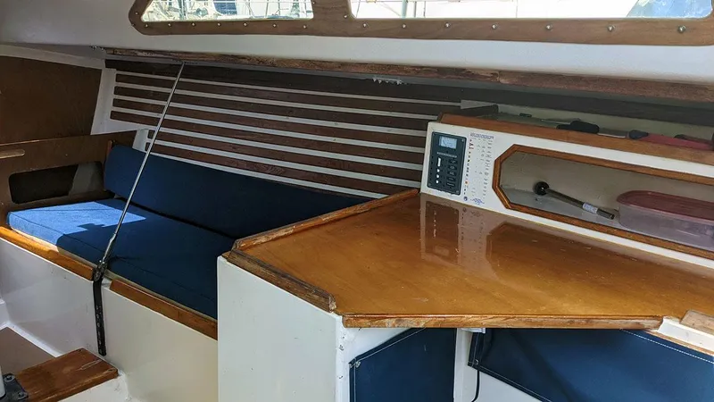 Slide: The Image of Interior of 1985 Soverel 33 sailboat with wooden table and blue seating. - 13
