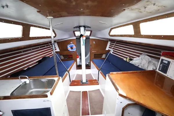Slide: The Image of Interior of 1985 Soverel 33 sailboat with wooden accents and blue seating. - 3