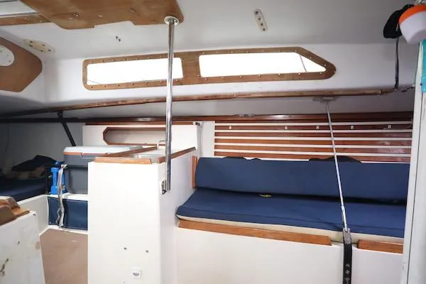 Slide: The Image of Interior of a 1985 Soverel 33 sailboat with blue seating and wooden accents. - 6