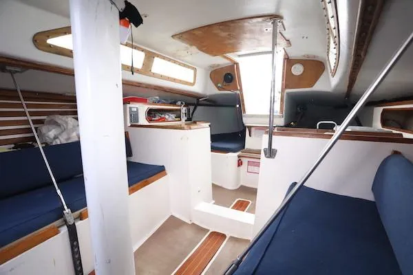 Slide: The Image of Interior of a 1985 Soverel 33 sailboat with blue seating and wooden accents. - 9