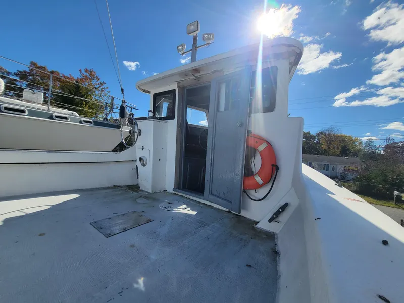 Slide: The Image of 1985 Kinnamon pilot house Chesapeake deadrise boat under sunny sky with life preserver. - 13