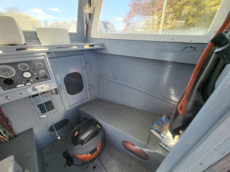 Slide: The Image of Interior of a 1985 Kinnamon Pilot House Chesapeake Deadrise boat with control panel and seating. - 17