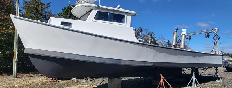 Slide: The Image of 1985 Kinnamon Pilot House Chesapeake Deadrise boat on land under clear blue sky. - 25