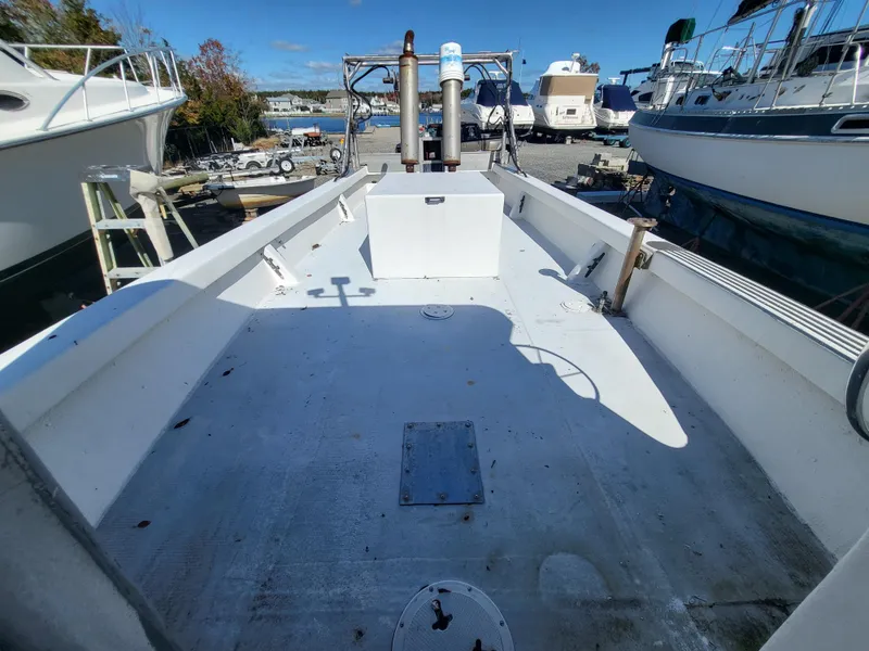 Slide: The Image of 1985 Kinnamon Pilot House Chesapeake Deadrise boat on dry dock, surrounded by other vessels. - 3