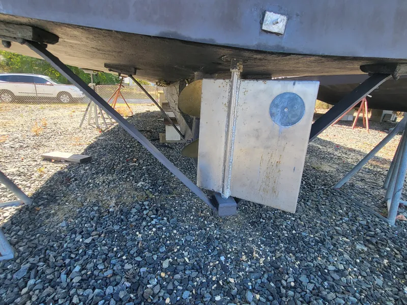 Slide: The Image of 1985 Kinnamon pilot house Chesapeake deadrise boat hull on gravel, supported by stands. - 31