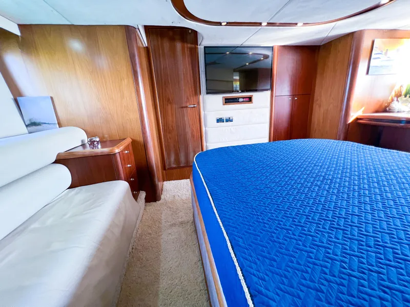 Slide: The Image of Luxurious interior of 2005 Sunseeker Predator 68 yacht with blue bedding and wood paneling. - 10