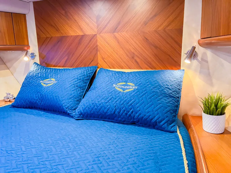 Slide: The Image of Luxurious Sunseeker Predator 68 yacht bedroom with blue bedding, wood accents, and modern lighting. - 18