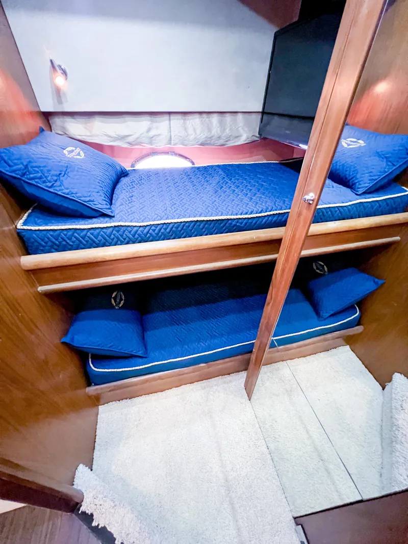 Slide: The Image of 2005 Sunseeker Predator 68 yacht cabin with blue bedding and wooden interior. - 21