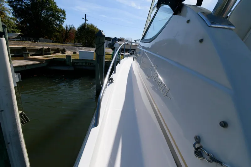 Slide: The Image of 2005 Stamas 320 Express boat docked, featuring sleek design and Suzuki 350 repower. - 12