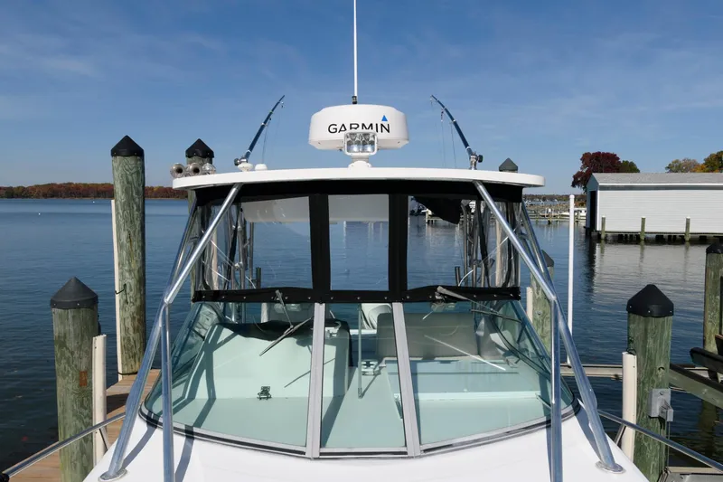 Slide: The Image of 2005 Stamas 320 Express boat with Suzuki 350 repower docked by calm waters. - 13