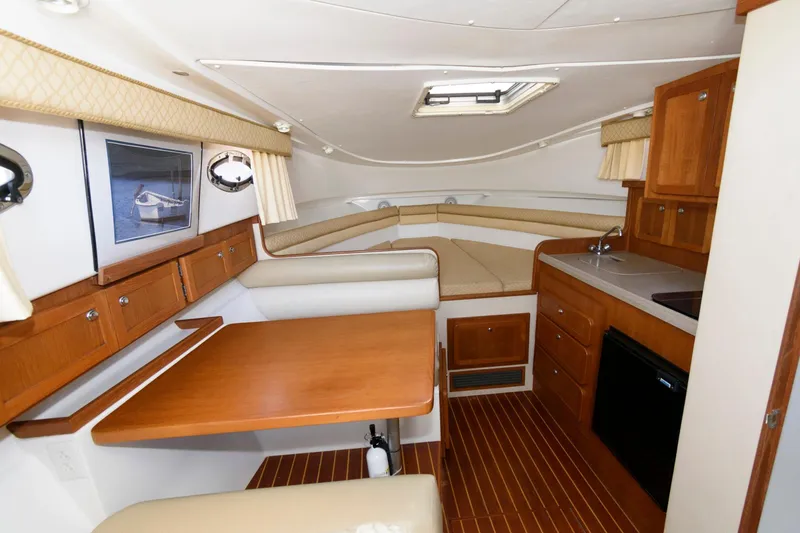 Slide: The Image of 2005 Stamas 320 Express cabin interior with wood finish, kitchenette, and seating area. - 15