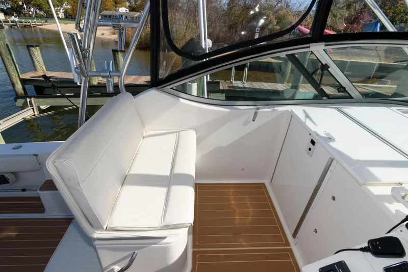 Slide: The Image of 2005 Stamas 320 Express boat interior with white seating and wood flooring. - 8
