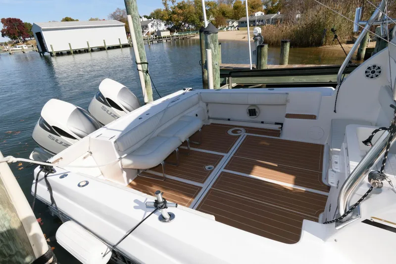 Slide: The Image of 2005 Stamas 320 Express boat with Suzuki 350 engines, docked, featuring spacious deck and seating. - 9