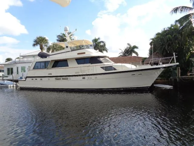 The Image of 1989 Hatteras 67 Cockpit Motor Yacht docked by palm trees. - 1