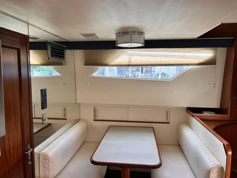 Slide: The Image of Interior of 1989 Hatteras 67 Cockpit Motor Yacht with dining area and seating. - 12