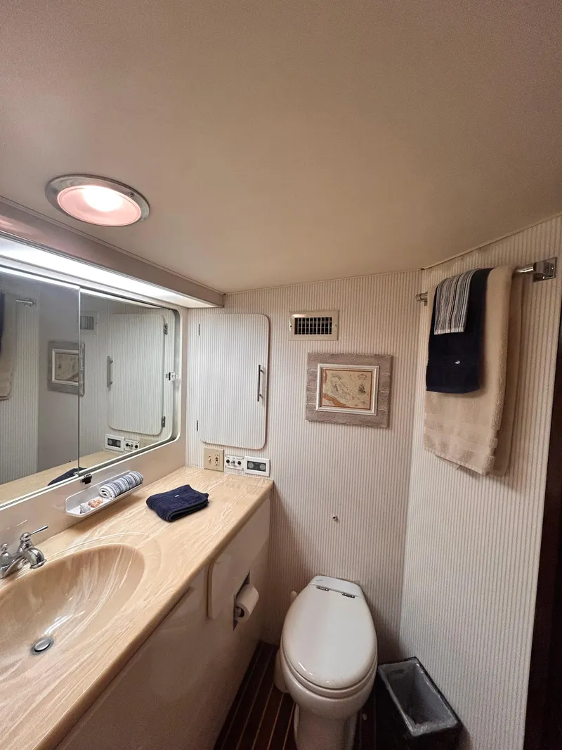 Slide: The Image of 1989 Hatteras 67 Cockpit Motor Yacht bathroom with sink, toilet, and mirror. - 20