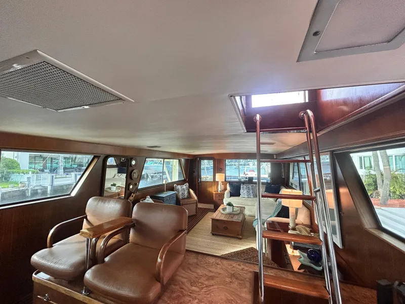 Slide: The Image of Interior of 1989 Hatteras 67 Cockpit Motor Yacht with leather seating and wooden accents. - 24