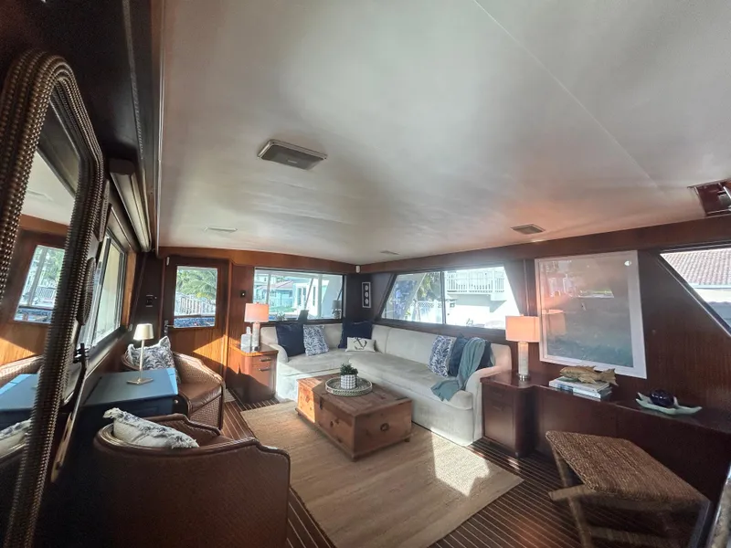 Slide: The Image of Interior of 1989 Hatteras 67 Cockpit Motor Yacht, featuring cozy seating and elegant decor. - 26