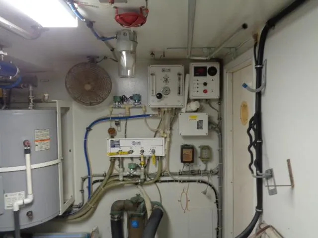 Slide: The Image of Engine room of 1989 Hatteras 67 Cockpit Motor Yacht with control panels and wiring. - 29
