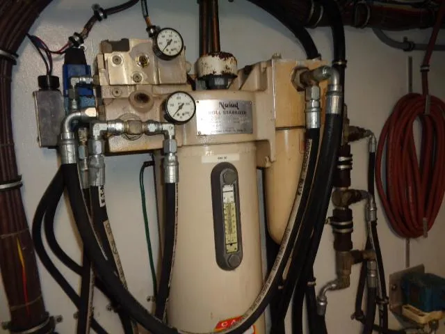 Slide: The Image of Engine room equipment of 1989 Hatteras 67 Cockpit Motor Yacht, featuring gauges and hoses. - 32