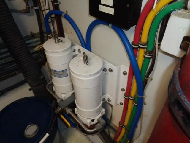 Slide: The Image of Engine room of 1989 Hatteras 67 Cockpit Motor Yacht with filters and colorful wiring. - 35