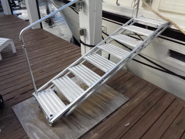 Slide: The Image of Aluminum gangway leading to 1989 Hatteras 67 Cockpit Motor Yacht on wooden dock. - 42