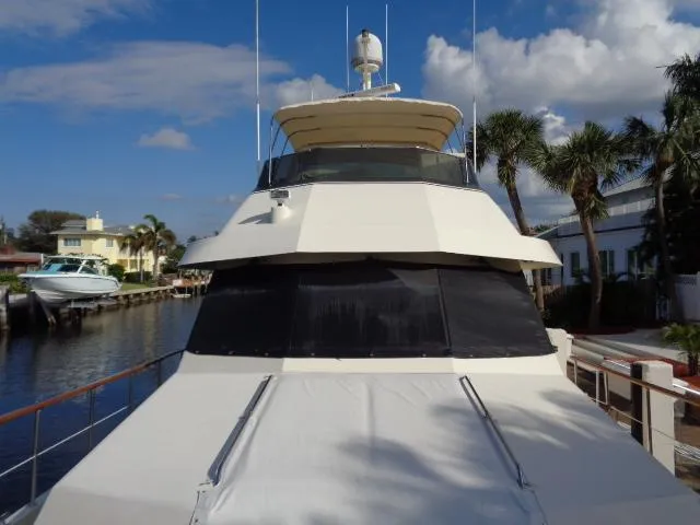 Slide: The Image of 1989 Hatteras 67 Cockpit Motor Yacht docked by palm trees under a blue sky. - 43