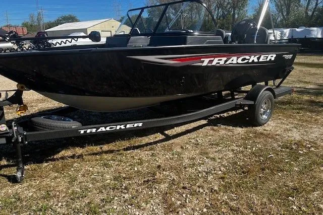 Slide: The Image of 2025 Tracker Pro Guide V-175 WT boat on trailer, parked outdoors. - 2