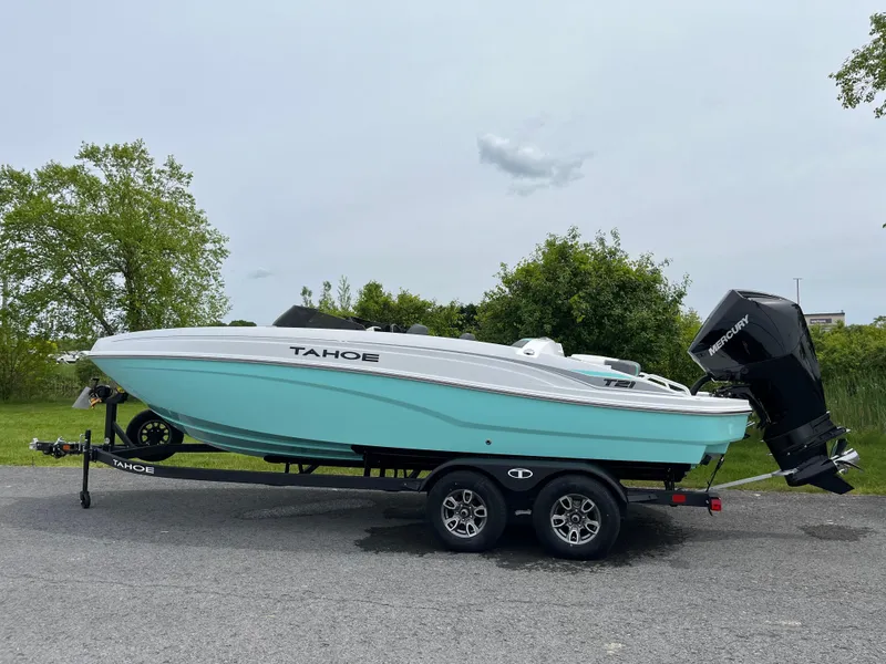 Slide: The Image of 2025 Tahoe T21 boat on trailer, light blue hull, parked outdoors. - 0