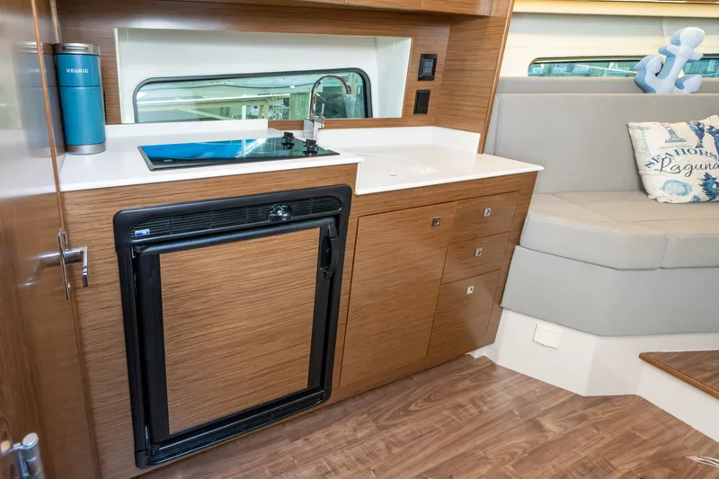 Slide: The Image of 2017 Cruisers Yachts 390 Express Coupe interior with kitchenette and seating area. - 35