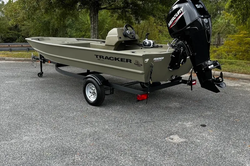 Slide: The Image of 2025 Tracker Grizzly 1648 SC boat with Mercury engine on trailer in outdoor setting. - 3