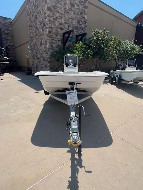 Slide: The Image of 2025 Mako Pro Skiff 17 CC boat on trailer, parked outdoors. - 2