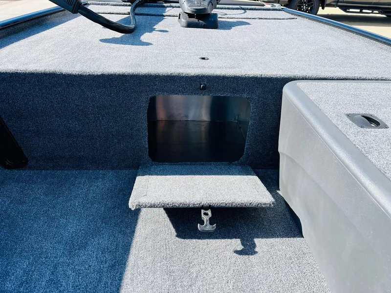 Slide: The Image of 2025 Tracker Bass Tracker Classic XL boat interior with carpeted deck and storage compartment. - 14