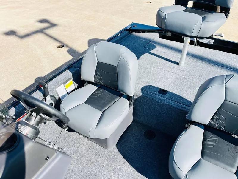 Slide: The Image of 2025 Tracker Bass Tracker Classic XL boat interior with gray seating and steering wheel. - 21
