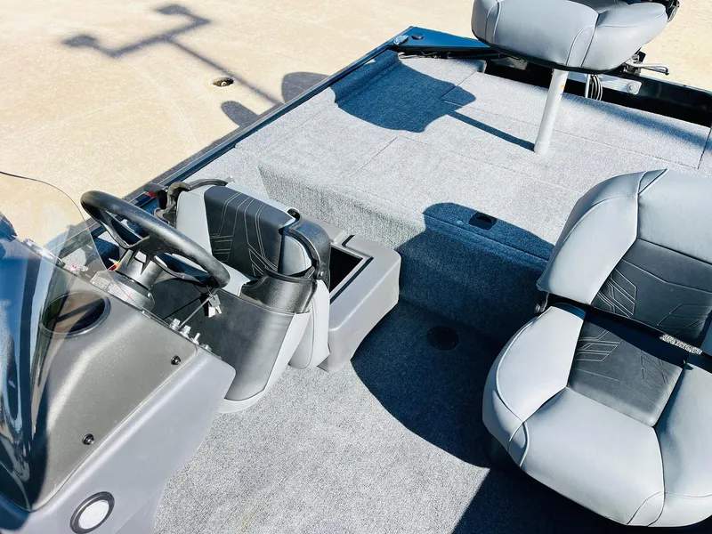Slide: The Image of 2025 Tracker Bass Tracker Classic XL boat interior with gray seating and steering console. - 22