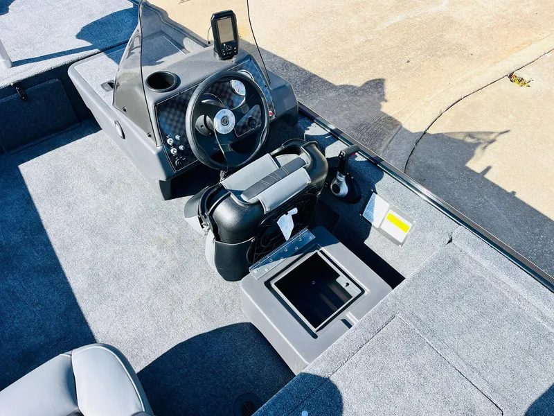 Slide: The Image of 2025 Tracker Bass Tracker Classic XL boat interior with steering wheel and storage compartment. - 23