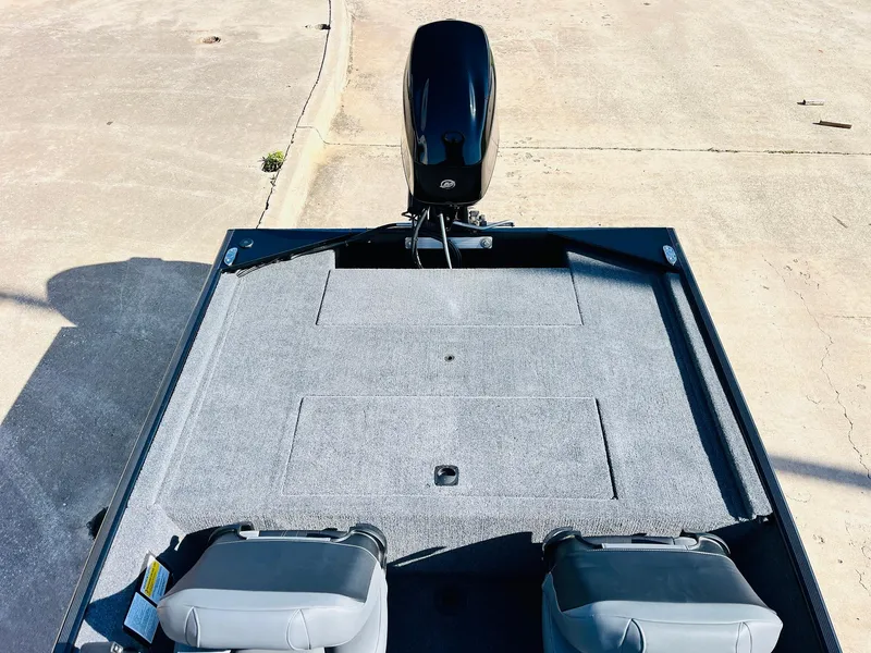 Slide: The Image of 2025 Tracker Bass Tracker Classic XL boat deck with motor, gray seating, and carpeted surface. - 27