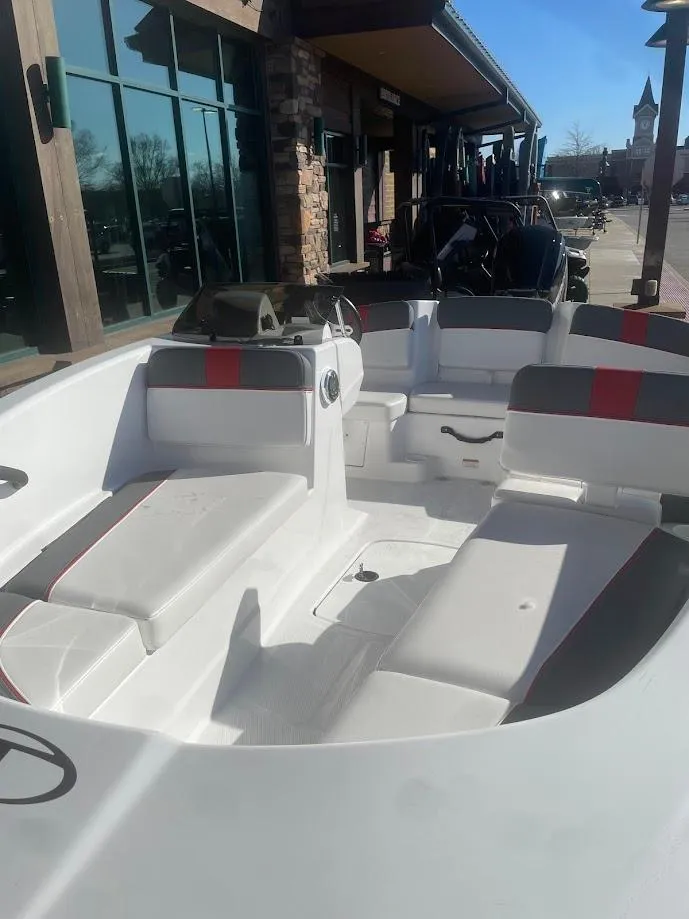 Slide: The Image of 2025 Tahoe T16 boat with spacious seating, docked near a modern building. - 3