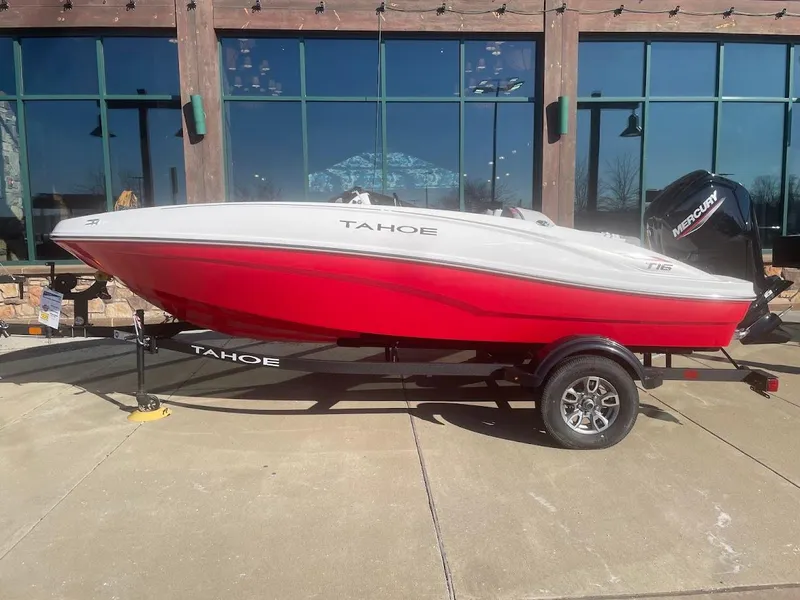 Slide: The Image of 2025 Tahoe T16 boat in red and white on a trailer, parked outdoors. - 44