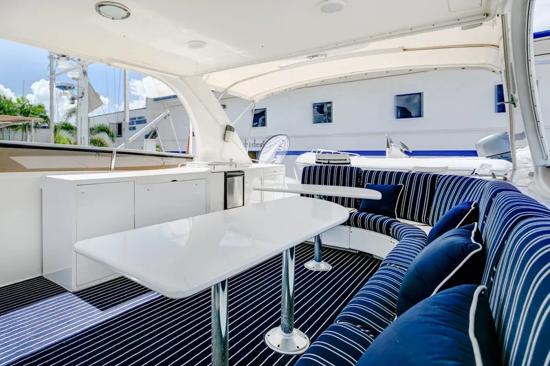 Slide: The Image of Luxurious 1994 Lazzara 76 yacht interior with striped seating and sleek white tables. - 13