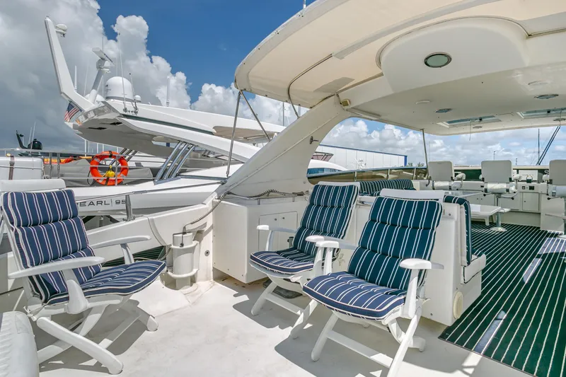 Slide: The Image of Luxury 1994 Lazzara 76 yacht deck with striped seating and clear skies. - 14