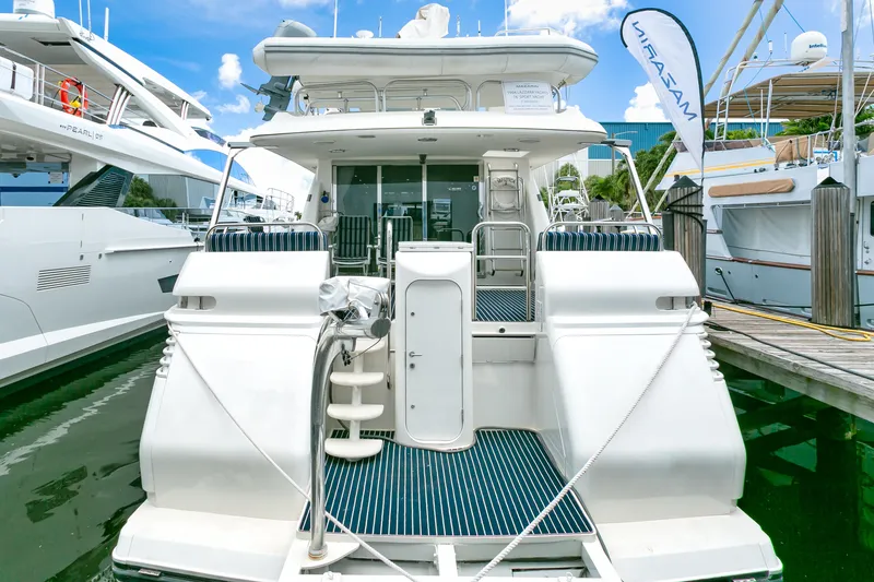 Slide: The Image of 1994 Lazzara 76 yacht docked, rear view with blue deck, marina setting. - 2