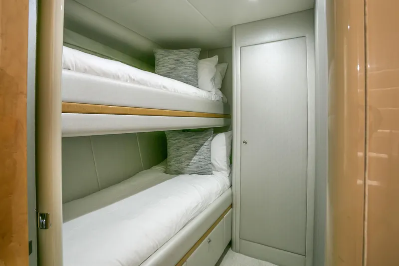 Slide: The Image of Bunk beds in a 1994 Lazzara 76 yacht cabin, featuring modern design and cozy bedding. - 23