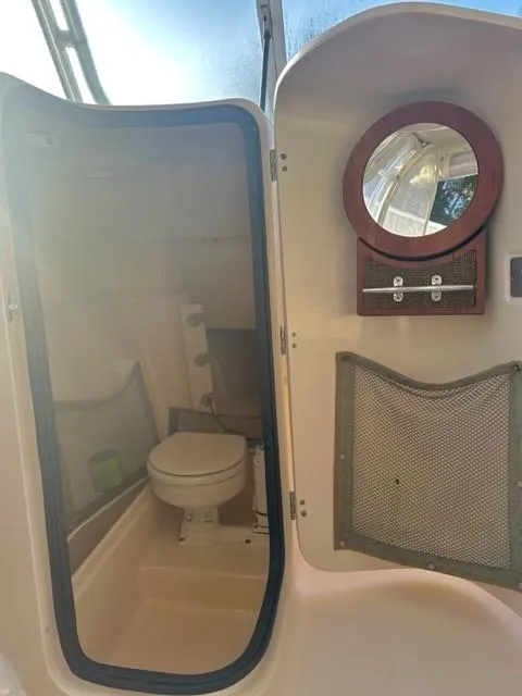 Slide: The Image of 2011 Grady-White Freedom 275 boat bathroom with toilet and mirror. - 7