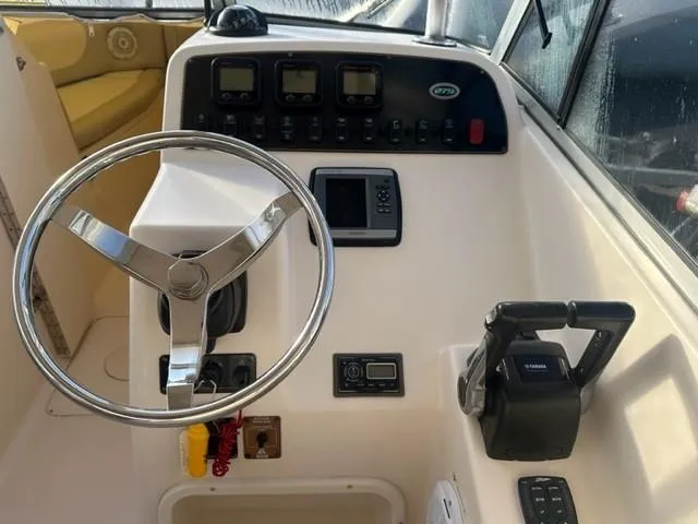 Slide: The Image of 2011 Grady-White Freedom 275 boat dashboard with steering wheel and controls. - 8