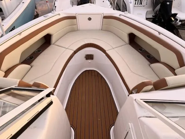Slide: The Image of Century 24 Resorter 2020 boat interior with cushioned seating and wood flooring. - 13