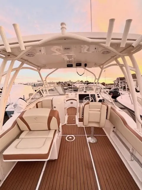 Slide: The Image of Century 24 Resorter 2020 boat interior with elegant seating and wood finish at sunset. - 14